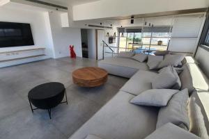 ein Wohnzimmer mit einem großen Sofa und einem Tisch in der Unterkunft Penthouse Sea View in Ben Yehuda by HolyGuest in Tel Aviv