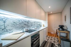 - une cuisine avec un comptoir en marbre et un évier dans l'établissement JOIVY Modern flat with patio in central Porto, à Porto