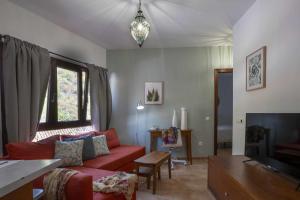 a living room with a red couch and a tv at Apartamento Gran Canaria La Mariposa in Vega de San Mateo