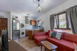 ein Wohnzimmer mit einem roten Sofa und einer Küche in der Unterkunft Apartamento Gran Canaria La Mariposa in Vega de San Mateo