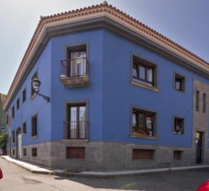 ein blaues Gebäude mit Fenstern und einem Balkon in der Unterkunft Apartamento Gran Canaria La Mariposa in Vega de San Mateo