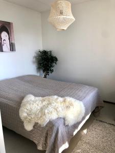 a bedroom with a bed with a white furry rug at Top floor one bedroom apartment with balcony in Helsinki