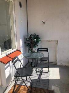 a table and chairs on a balcony with a plant at Top floor one bedroom apartment with balcony in Helsinki