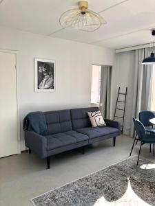a living room with a blue couch and a table at Top floor one bedroom apartment with balcony in Helsinki