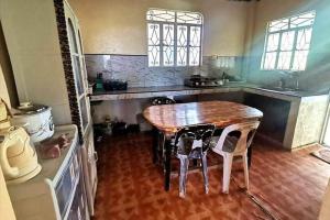 een keuken met een houten tafel en stoelen. bij Albert's Transient House in Batangas City