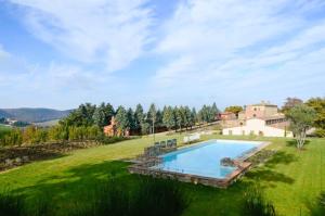 Osteria Delle NociにあるISA - Luxury Resort with swimming pool immersed in Tuscan nature, apartments with private outdoor area with panoramic viewの緑地の水場付き邸宅