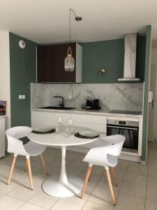 cocina con mesa blanca y 2 sillas en Le Benvegnu, en Chambéry