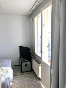 a bedroom with a window and a bed and a television at Top floor one bedroom apartment with balcony in Helsinki