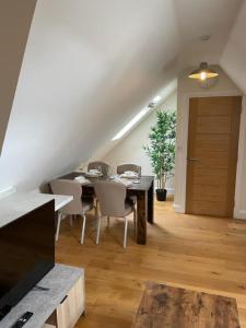 a dining room with a table and chairs and a staircase at Two Bedroom Duplex Apartment The Priory - St Ives in St. Ives