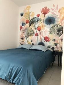- une chambre avec un lit bleu et un mur fleuri dans l'établissement Le Benvegnu, à Chambéry