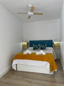 una camera con un grande letto e un ventilatore a soffitto di La Churrera alojamiento rural a Yunquera