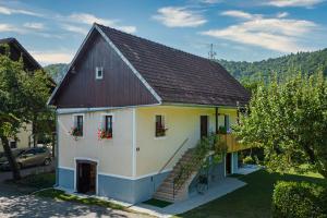 uma pequena casa branca com um telhado castanho em Kolpa Zupančič Vineyard Apartments - Happy Rentals em Stari Trg ob Kolpi