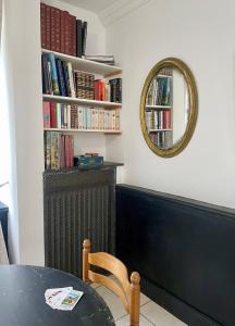 Habitación con mesa, espejo y libros. en Grand gîte pour 28 personnes dans un château en Normandie en Beuzevillette