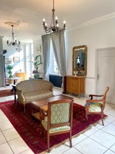 uma sala de estar com um sofá e um espelho em Grand gîte pour 28 personnes dans un château en Normandie em Beuzevillette
