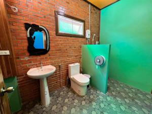 uma casa de banho com um lavatório, um WC e um espelho. em ชานไม้ รีสอร์ท 