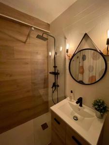 y baño con lavabo y ducha con espejo. en La Churrera alojamiento rural, en Yunquera