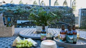 a table with bottles of wine and grapes on it at Pencoed in Llanbedrog