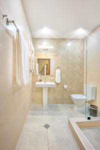 a bathroom with a sink and a toilet at Solo Grand Boshuri Hotel Wellness Resort 