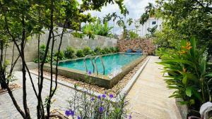 a swimming pool in the middle of a garden at Holy Angkor Hotel in Siem Reap