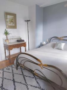 a bedroom with a bed with a desk and a table at Gîte les deux sources au pied du Vercors in Saint-Laurent-en-Royans