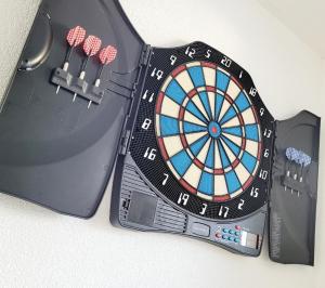 a dart board with darts next to a laptop at SW House Paris Stade de France CDG in Le Blanc-Mesnil