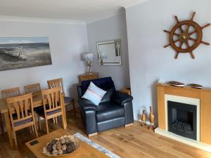 a living room with a black leather chair and a table at 8Murrayfield, St Abbs in Saint Abbs