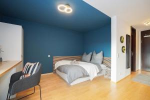 a bedroom with a bed with a blue wall at LINDE3 - 10 Minuten in die Altstadt mit Balkon und Pegnitzblick in Nürnberg