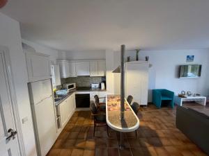eine Küche mit einem Tisch in der Mitte eines Zimmers in der Unterkunft Apartament z widokiem na morze in Son Xoriguer