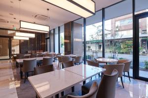 a restaurant with tables and chairs and large windows at Tosei Hotel Cocone Tsukiji Ginza Premier in Tokyo