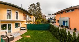 a backyard of a house with a green fence at Urlaubstraum in Salzburgs Toplage in Salzburg
