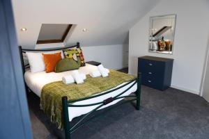 Fred's Place في بلايموث: غرفة نوم مع سرير مع وسائد برتقالية وأخضر