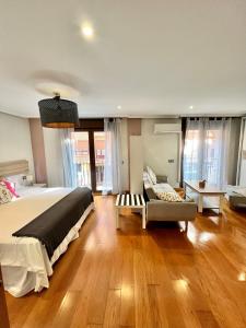 een slaapkamer met een groot bed en een bank bij Apartamentos San Antonio in Aranda de Duero