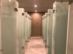 a row of stalls in a bathroom with a hallway at PassGo Digital Airport Terminal 2 Soekarno Hatta in Rawabagol