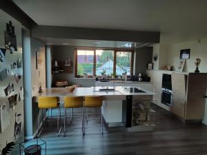 a kitchen with a large island with yellow bar stools at Einzigartiges Haus mit Pool großem Garten und Kamin in Bad Salzungen