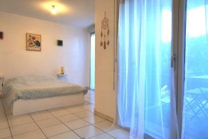 Ένα ή περισσότερα κρεβάτια σε δωμάτιο στο Grand studio lumineux et sa terrasse au calme