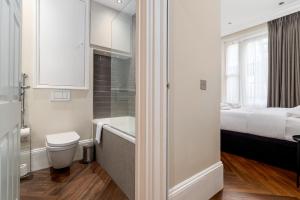 a bathroom with a toilet and a tub and a bed at 1BR gem in the heart of Covent Garden with aircon in London