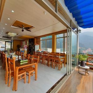 a dining room with a table and chairs and windows at Phượng Chi Homestay Venuestay in Tam Ðảo