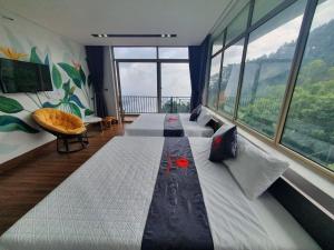 a bedroom with a large bed with a large window at Phượng Chi Homestay Venuestay in Tam Ðảo