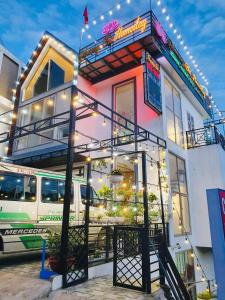 a building with a bus parked in front of it at Phượng Chi Homestay Venuestay in Tam Ðảo