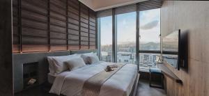 1 dormitorio con cama grande y ventana grande en The Stellar, en Hong Kong