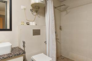 Hotel A4U sector 45 Gurgaon في جورجاون: حمام مع دش ومرحاض