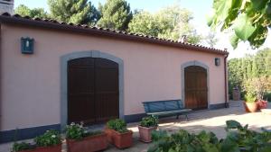 budynek z dwoma drzwiami garażowymi i ławką w obiekcie Romantic Etna house Etna Mare w mieście Pedara