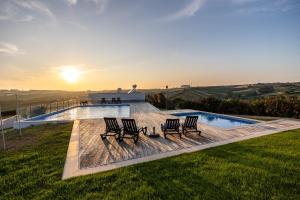 a group of chairs sitting next to a swimming pool at Carina Villas in Lourinhã