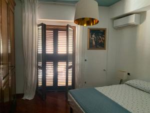 a bedroom with a bed and a window with blinds at Kasakarin in Scilla