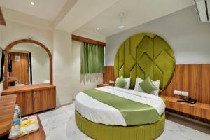 een slaapkamer met een groot bed met een groot hoofdeinde bij HOTEL ROYAL 21 in Ahmedabad