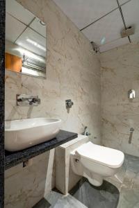 a white bathroom with a sink and a toilet at HOTEL ROYAL 21 in Ahmedabad