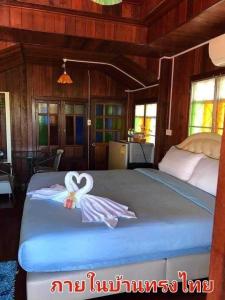 a bedroom with a bed with two swans on it at The Memorize Resort in Ban Non Na Yao