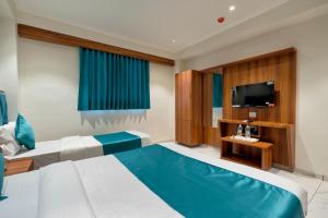 Habitación de hotel con cama y TV en HOTEL ROYAL 21 en Ahmedabad