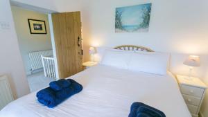 una camera da letto con un letto bianco e asciugamani blu di Aber a Moelfre