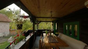 eine Veranda mit einem Holztisch in einem Haus in der Unterkunft La Răscoala in Petrila